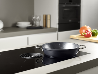 Beschichtete Servierpfanne der Fissler Serie Adamant® auf dem Induktionsfeld