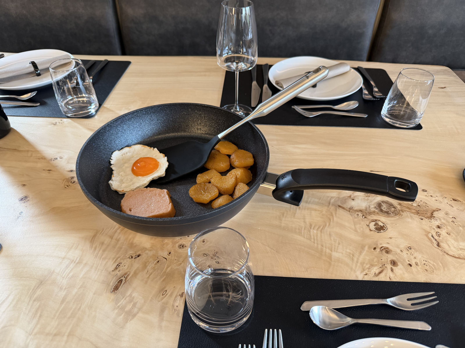 Beschichtete Stielpfanne der Fissler Serie Adamant® beim servieren am Tisch
