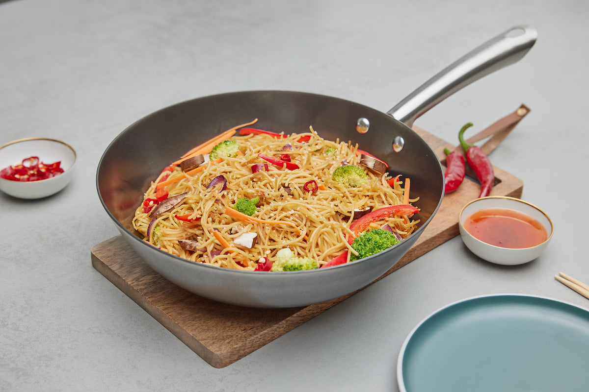 Zubereitung asiatischer Gerichte in einer Eisenpfanne von Schulte-Ufer