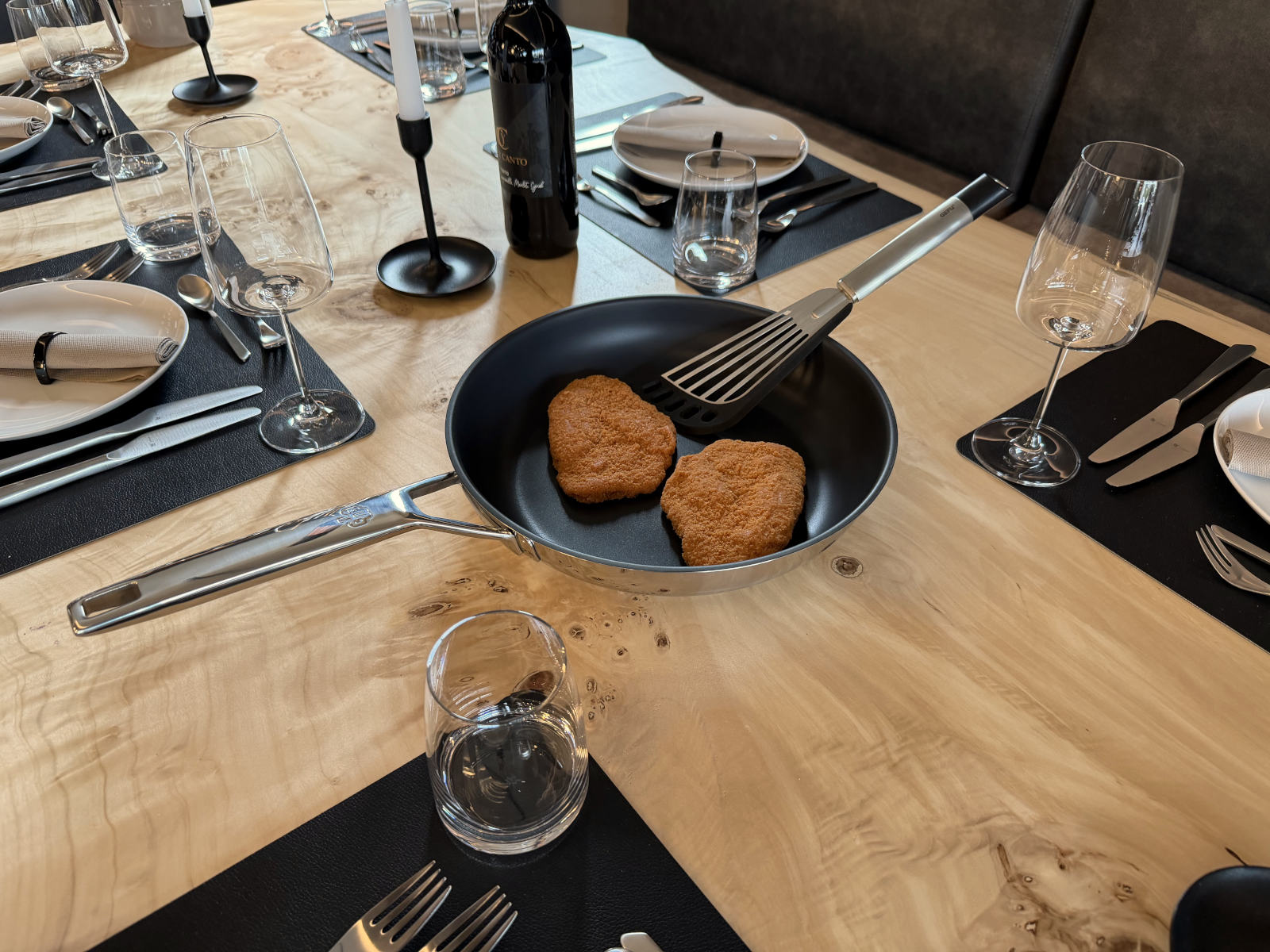 Unbeschichtete Schulte-Ufer Astral Stielpfanne mit Pfannengericht und GEFU Pfannenwender auf dem Tisch